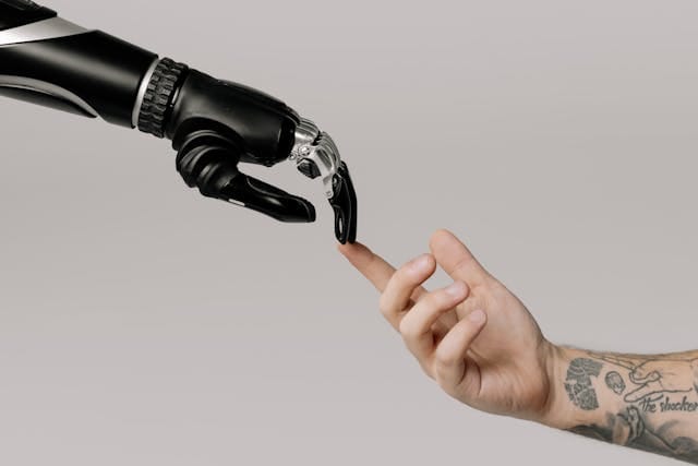 Zestawienie dłoni ludzkiej i czarnej, bionicznej ręki robota stykających się palcami, symbolizujące interakcję człowieka ze sztuczną inteligencją i pytania o to, czy klienci ufają treściom AI.