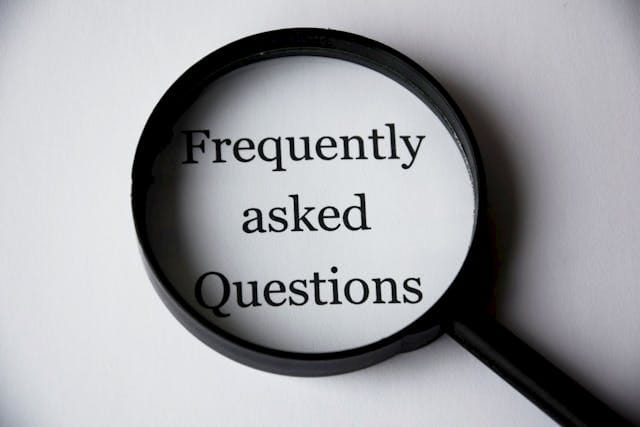 Artystyczne ujęcie czarnej lupy położonej na białym papierze z wydrukowanym napisem „Frequently asked Questions”. Obraz symbolizuje drobiazgową analizę danych strukturalnych, którą przeprowadza Contentologia, aby zrozumieć, jak usunięcie Faq z rich snippet Google wpłynie na czytelność i transparentność informacji w wynikach wyszukiwania.